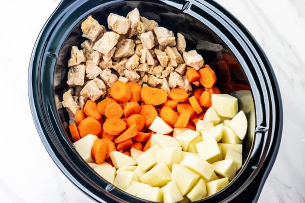 diced chicken, potatoes and carrots in a crock pot