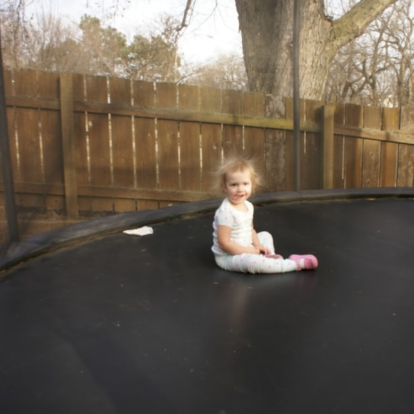 toddler sitting on trampoline