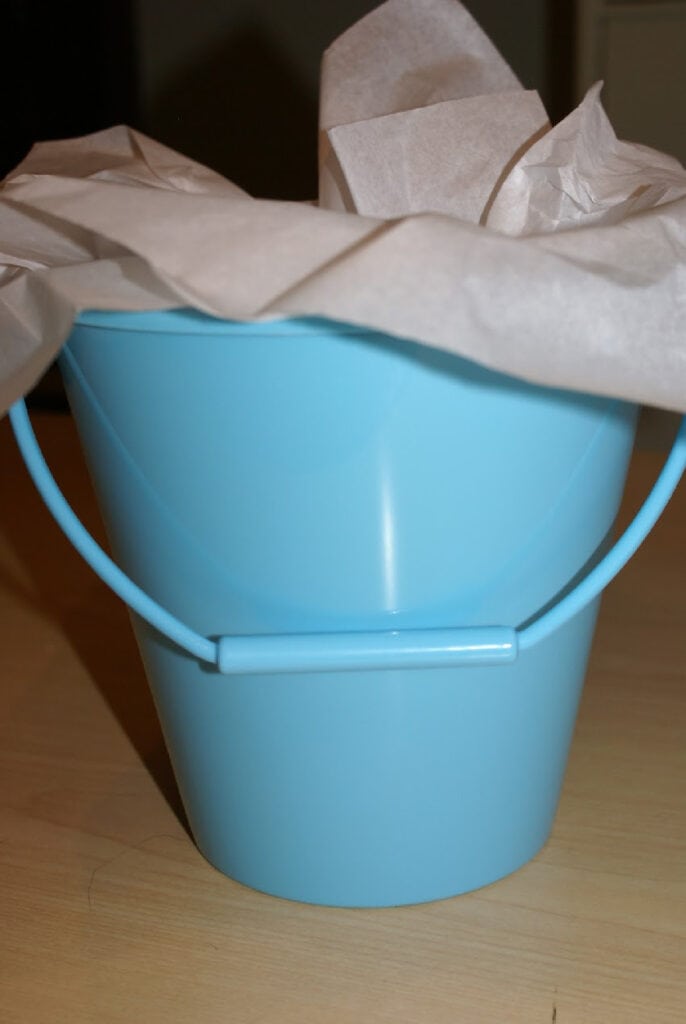 blue pail with tissue paper in it