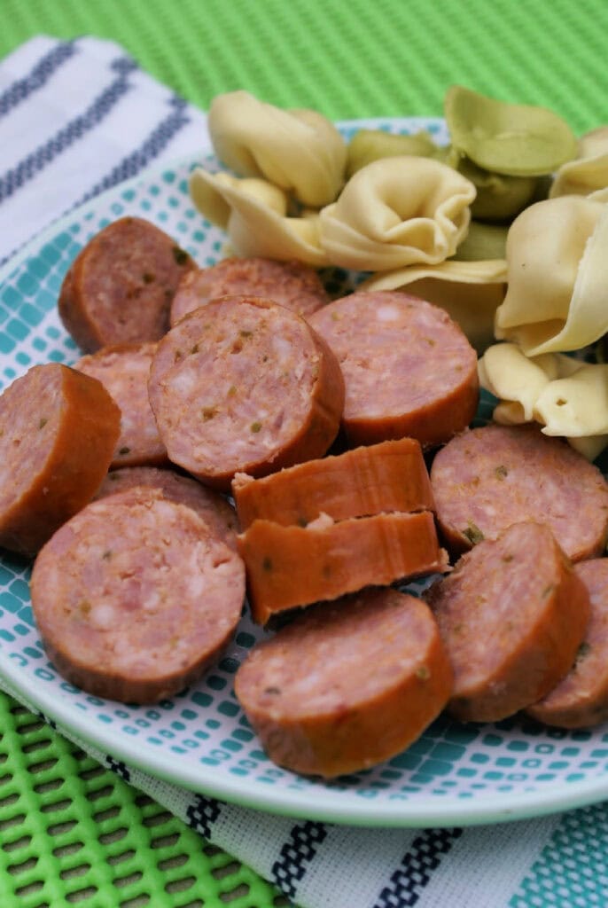 plate of sliced sausage and tortellini