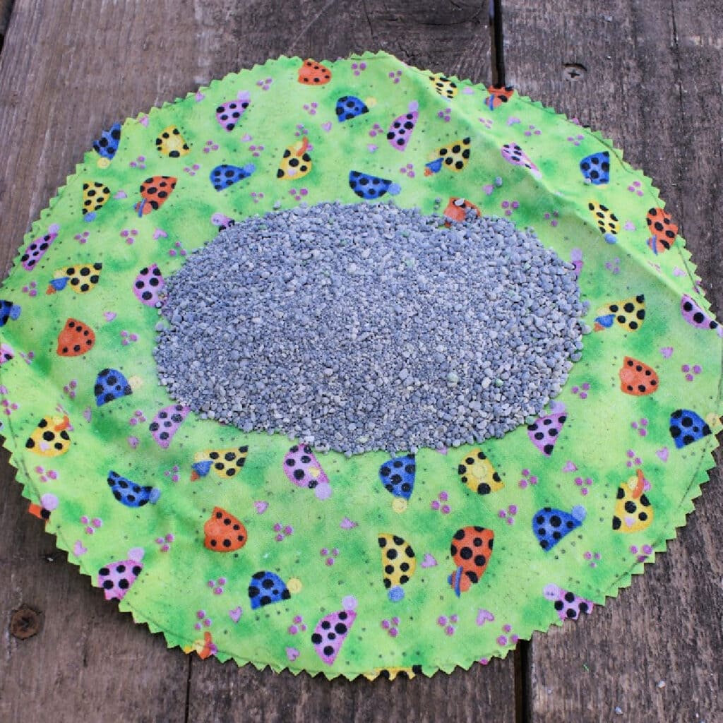 round piece of material with cat litter on the top