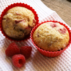2 raspberry muffins on table