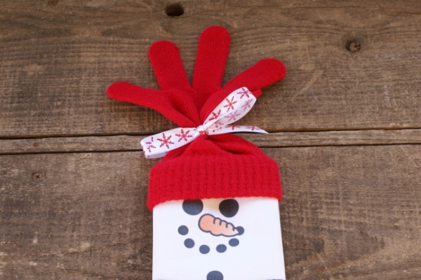 tieing a ribbon around gloves to make a snowman hat