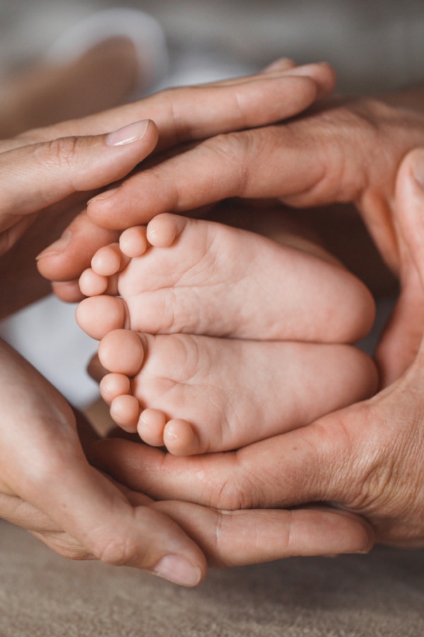 baby feet and hands surrounding the feet