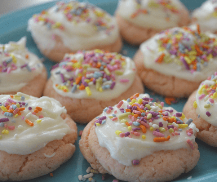 pink cookies with a white glaze and colorful sprinkles