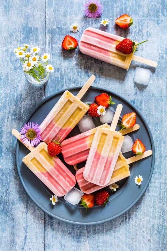 plate of fruity ice lollies with flower garnish