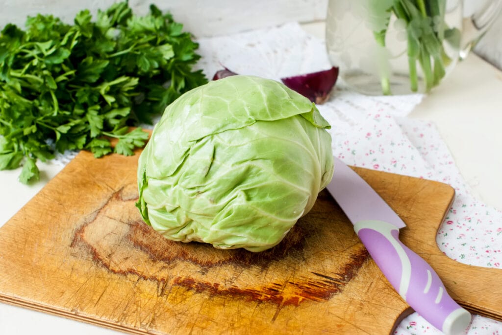 head of cabbage on a cutting board with a knife