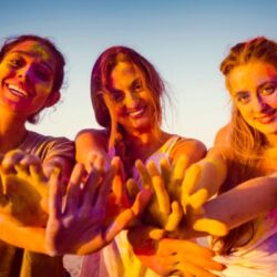 three girls with paint on their hands smiling