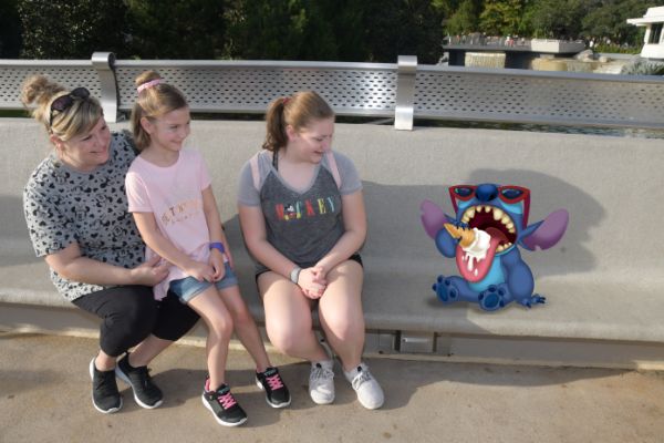 three people sitting down looking at a cartoon character