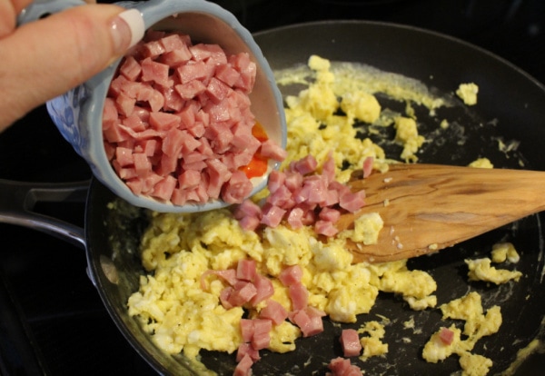 cooking eggs and ham in skillet