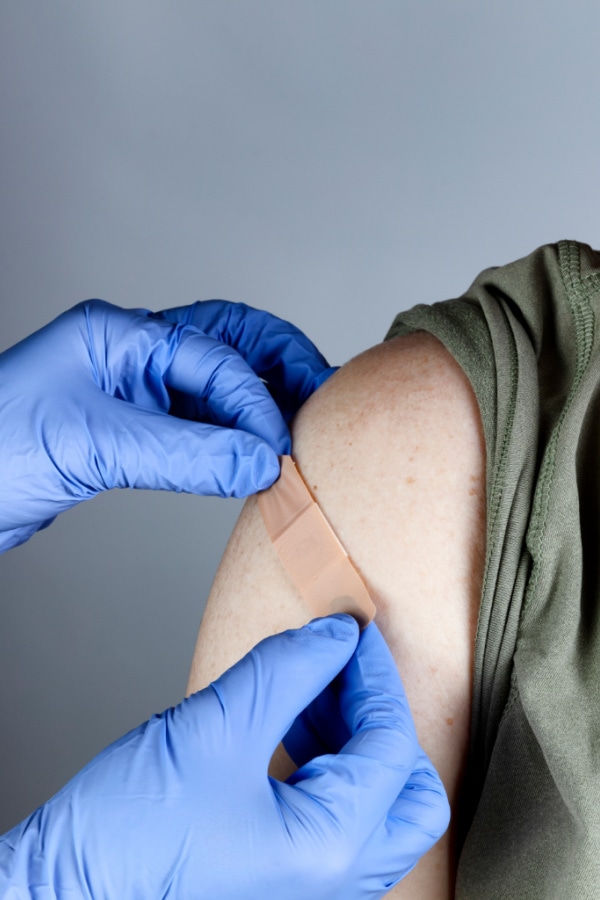 bandaid being put on an arm after a shot