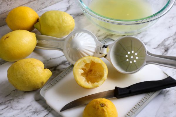 lemons on counter with some cut up and squeezed