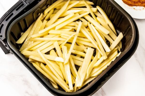 homemade french fries in the air fryer basket uncooked