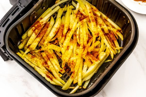 seasoned nacho fries in the air fryer ready to be cooked