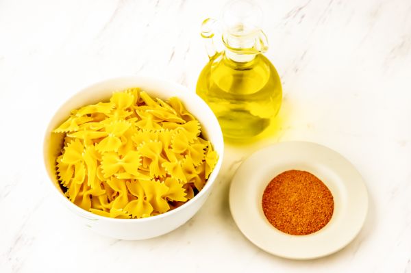 Bowl of pasta, spices and jar of oil