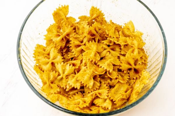 Pasta in bowl with seasoning mixed in