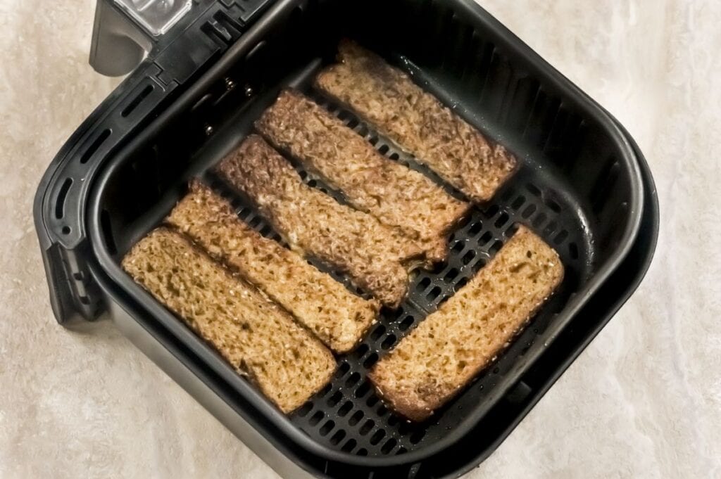 french toast sticks in air fryer basket cooking