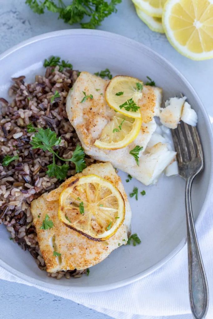 Cod fish on a plate with brown rice