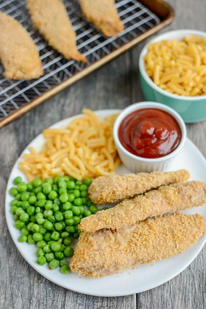 Plate of Chicken tenders with peas and fries
