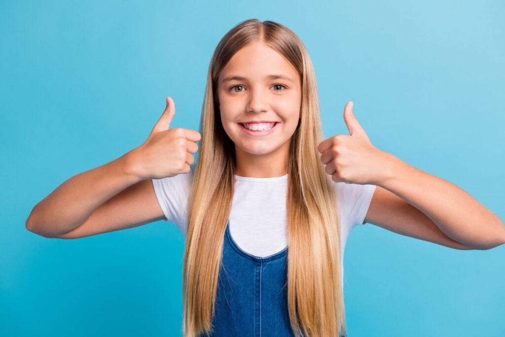 girl giving the thumbs up sign with both hands