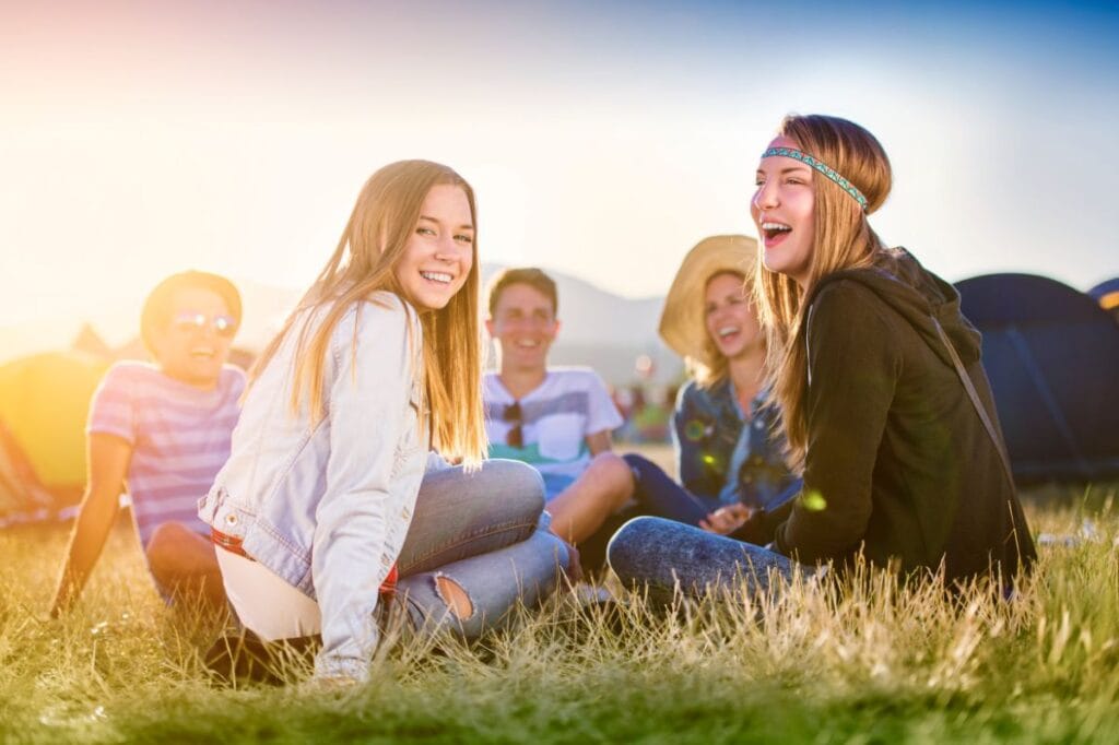 group of teens sitting smiling in the sunshine