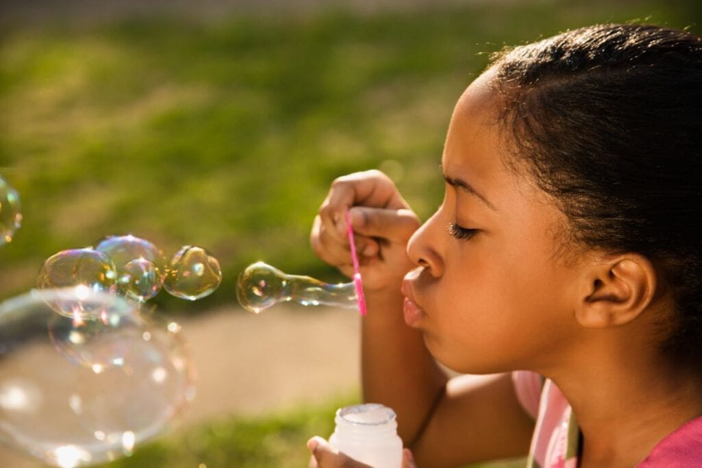 little girl blowing bubbles
