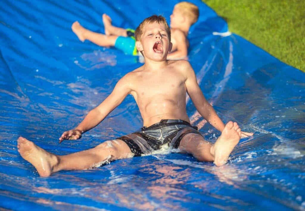 two boys on a slip and slide