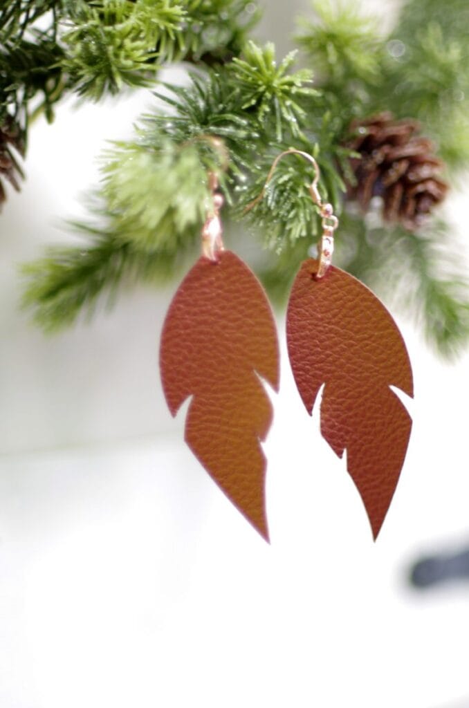 Brown leather earrings hanging on a christmas tree