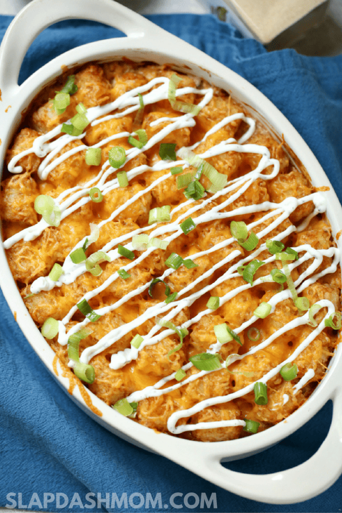 Tater Tot Casserole drizzled with white sauce and green onions