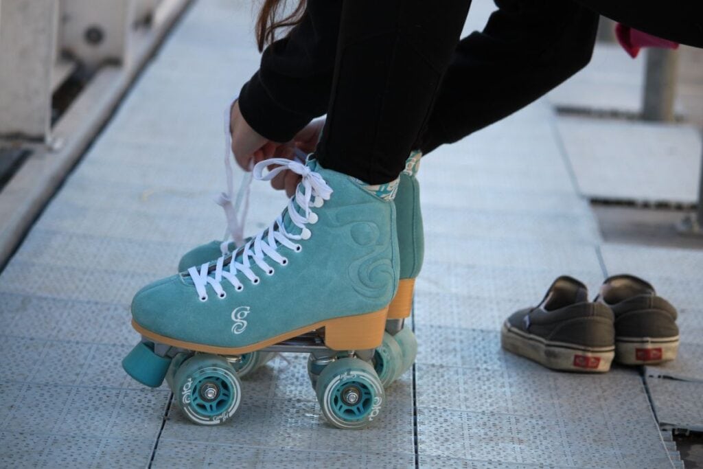girl tying her blue roller skates