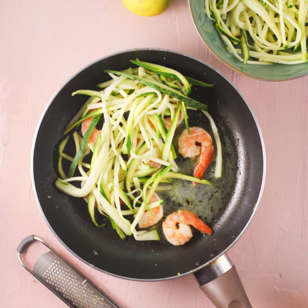 pan with oil, shrimps, and zucchini