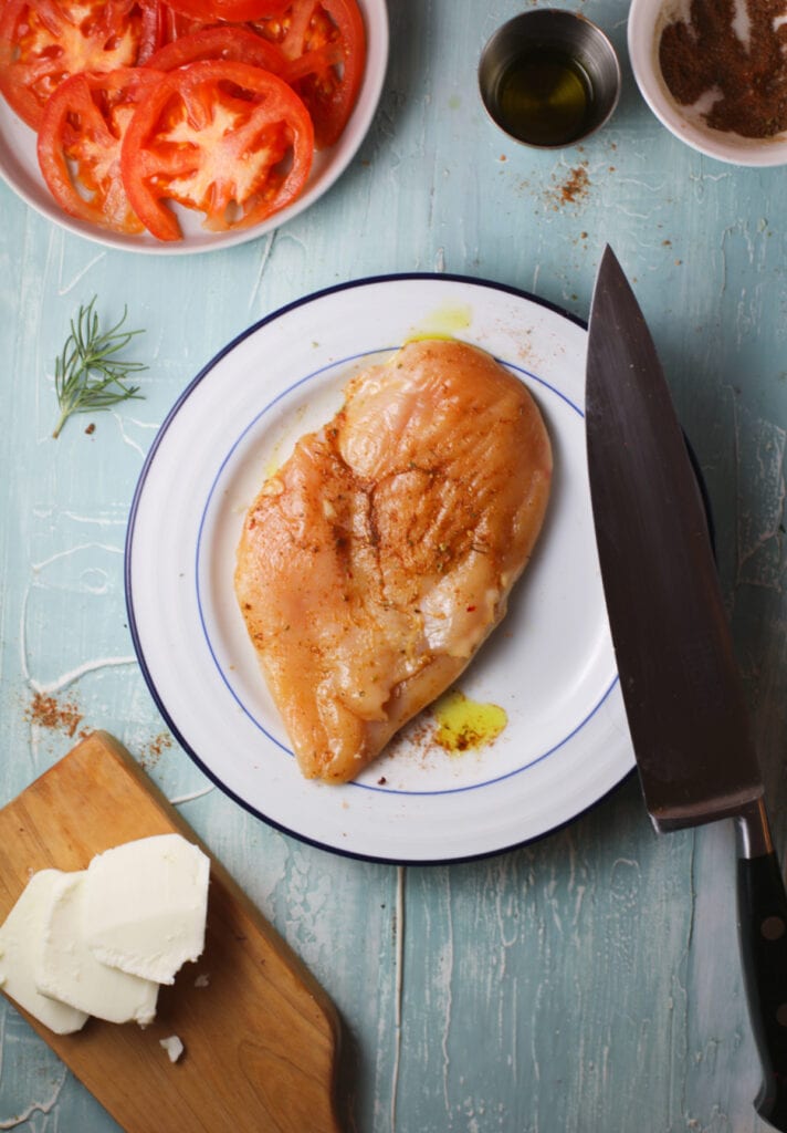 oil and seasonings on chicken breast