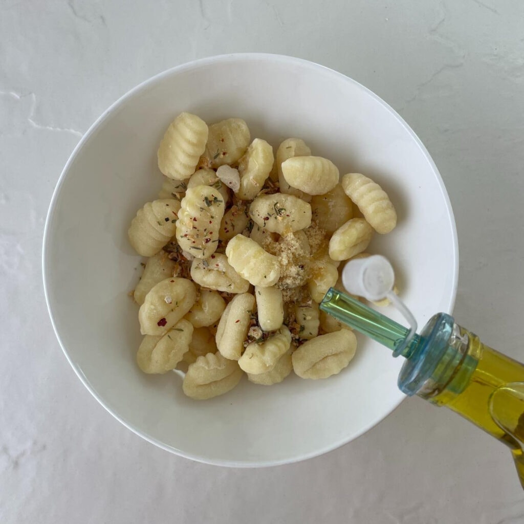 Gnocchi with seasoning and oil in a bowl