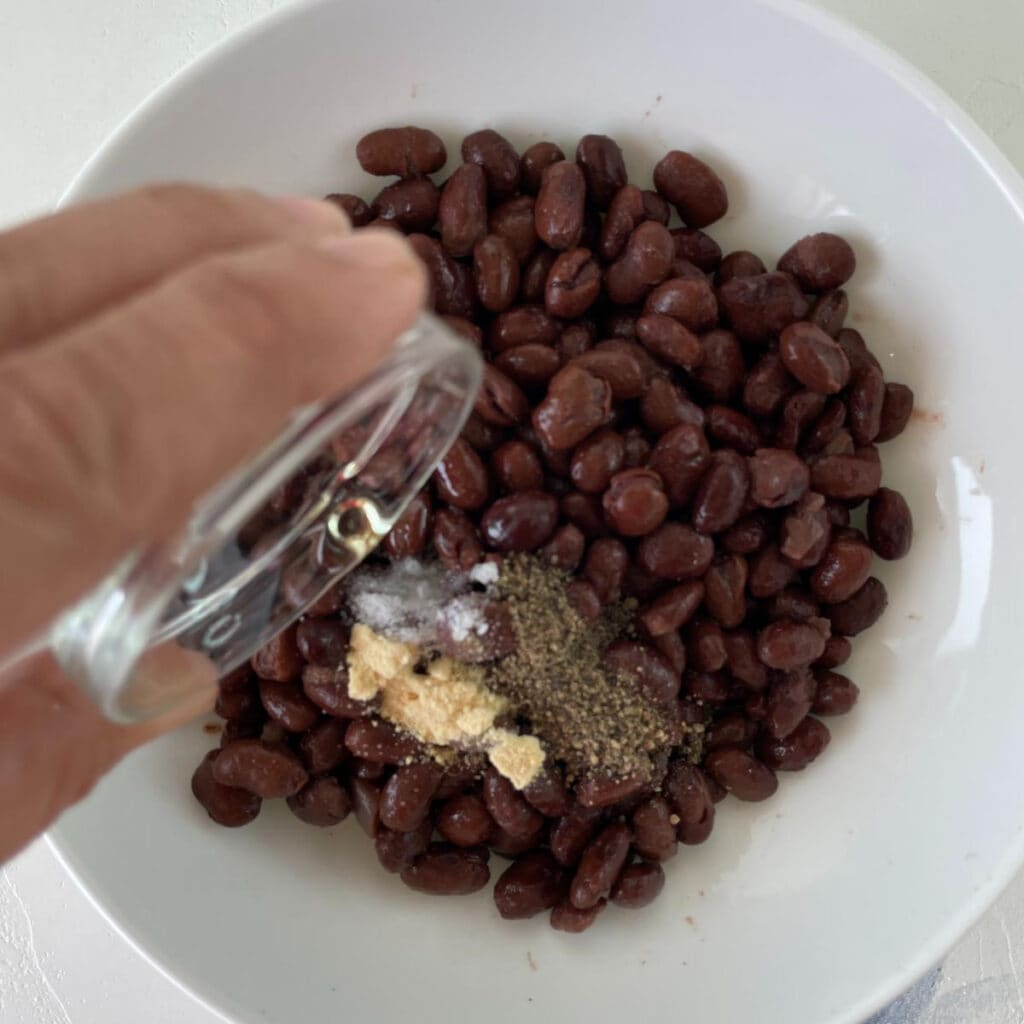 adding seasonings to the black beans