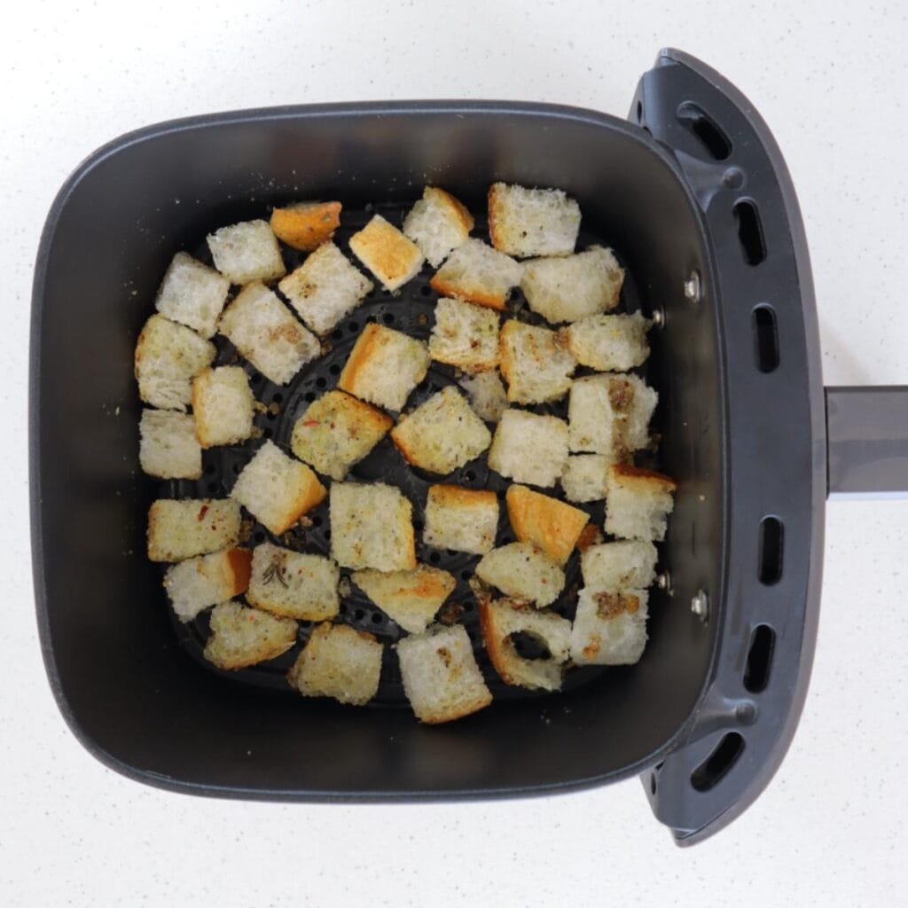 Cubed bread in an air fryer basket