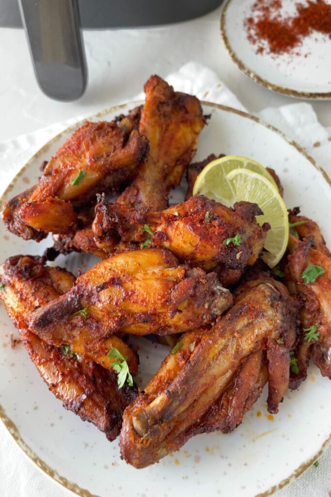 plate of air fried chicken wings with lemon and garnish