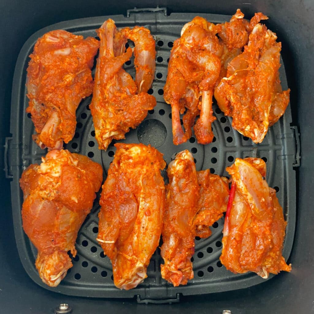 layer of chicken wings in an air fryer basket