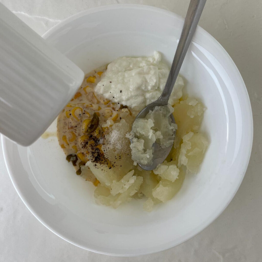 mashed potatoes and other ingredients in a mixing bowl