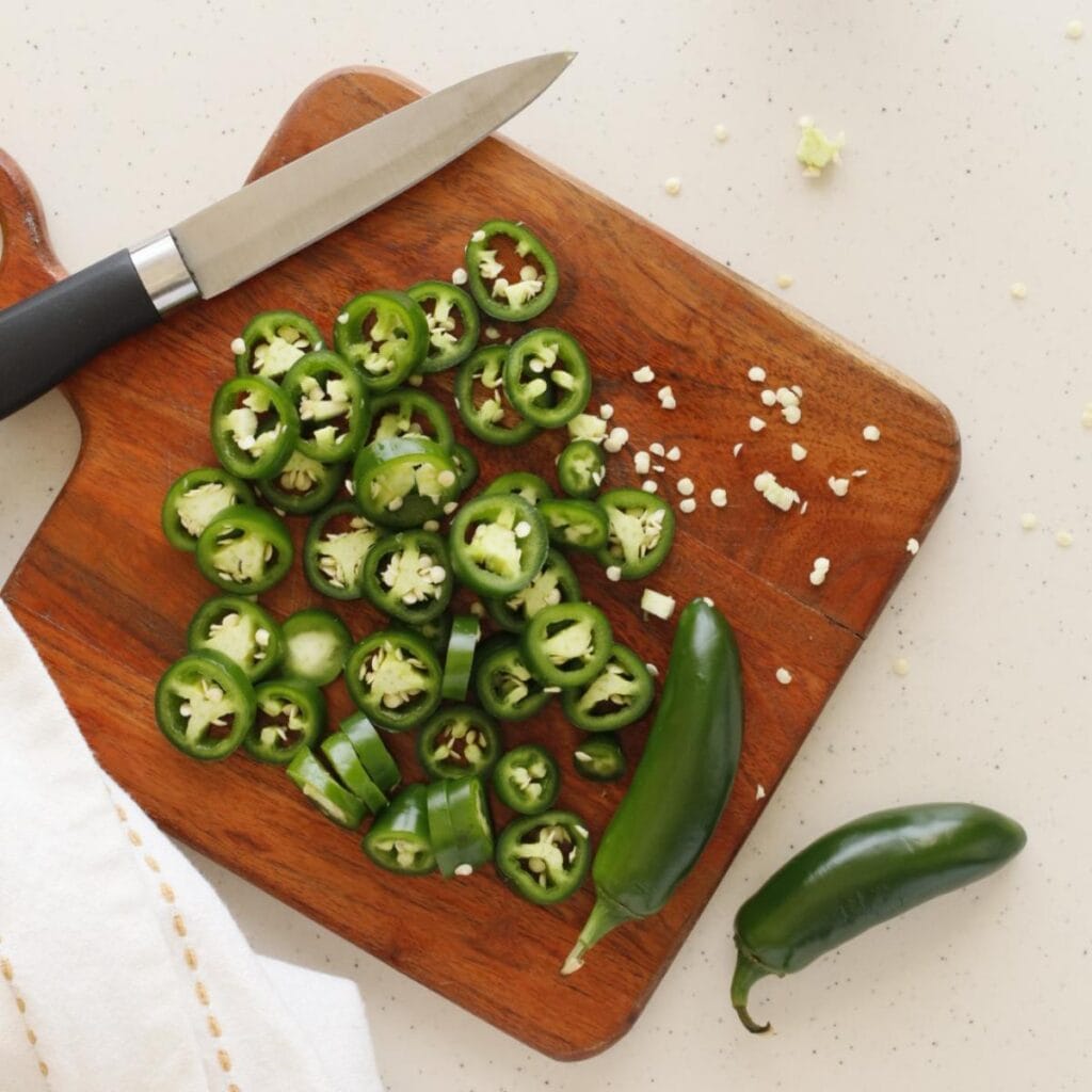 sliced jalapenos on a chopping board