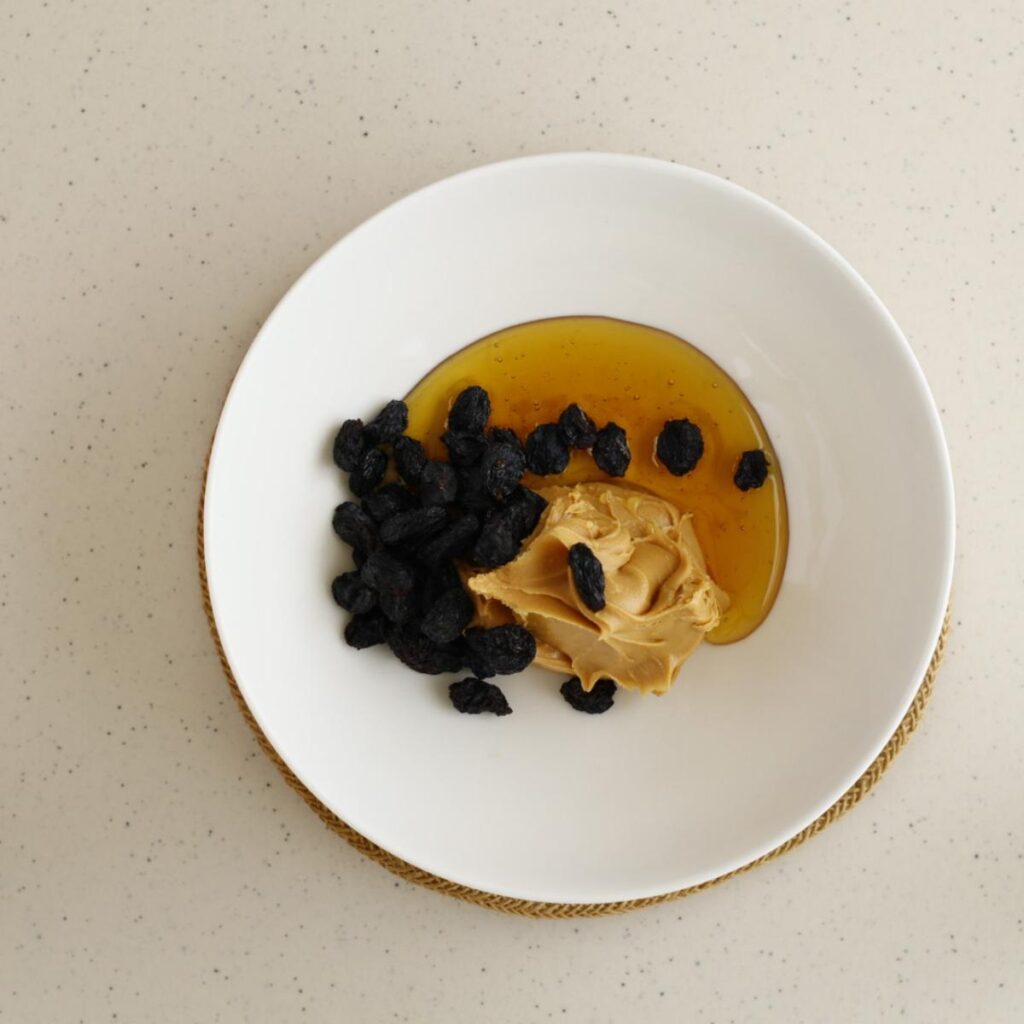 honey, peanut butter, and raisins in a mixing bowl