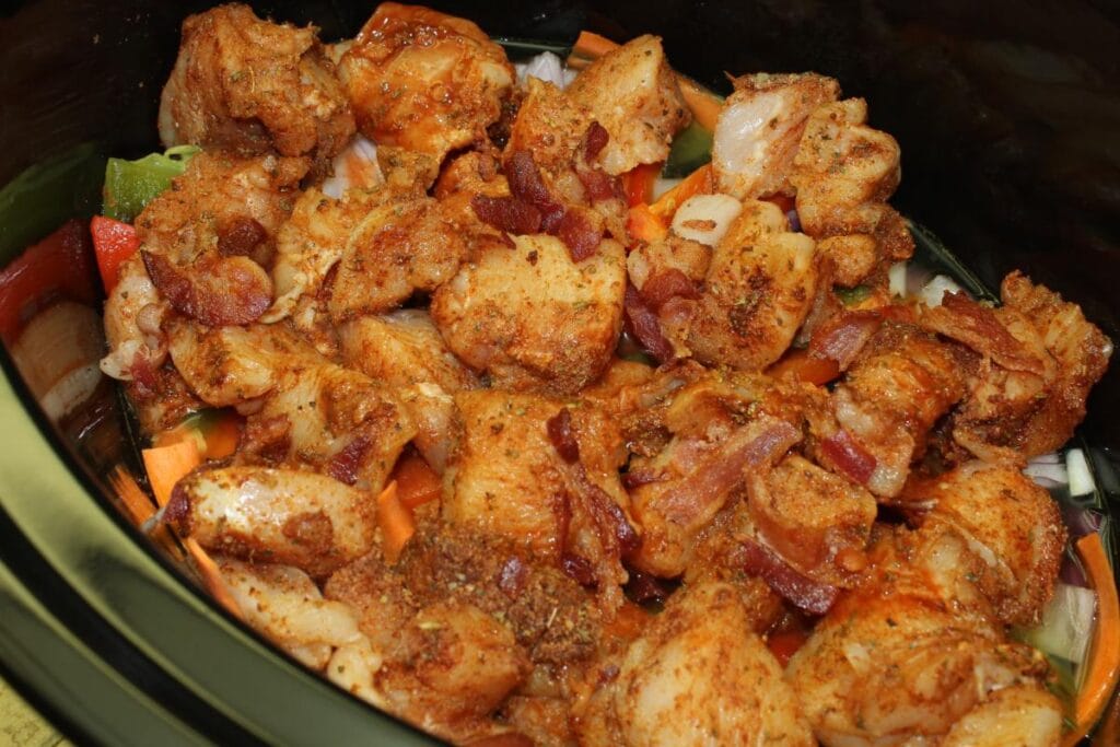 uncooked chicken and vegetables in a slow cooker