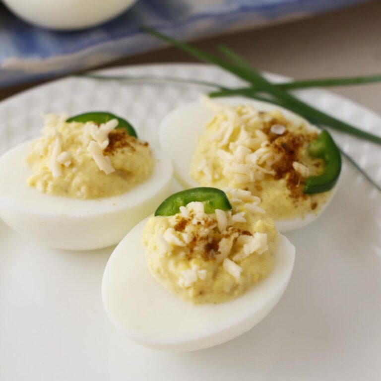 close up view of hard boiled eggs with jalapeno and cheese