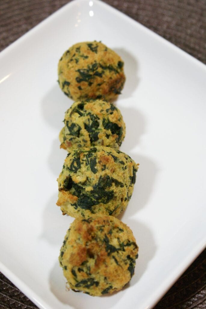 4 pieces of spinach balls on a plate