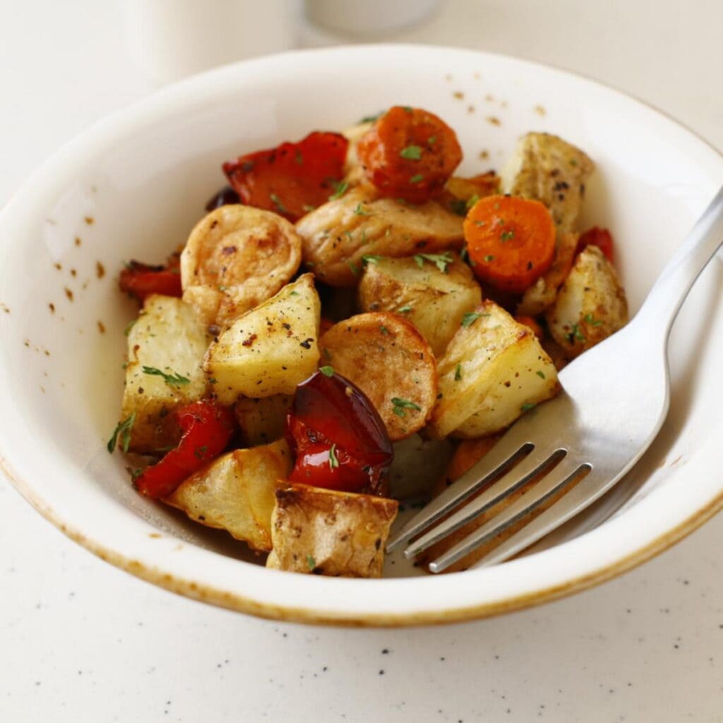 Bowl of roasted potatoes, bell pepper, and carrots
