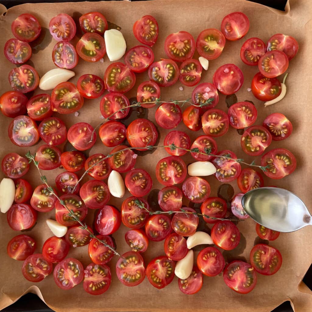 tomatoes on a baking pan drizzled with oil