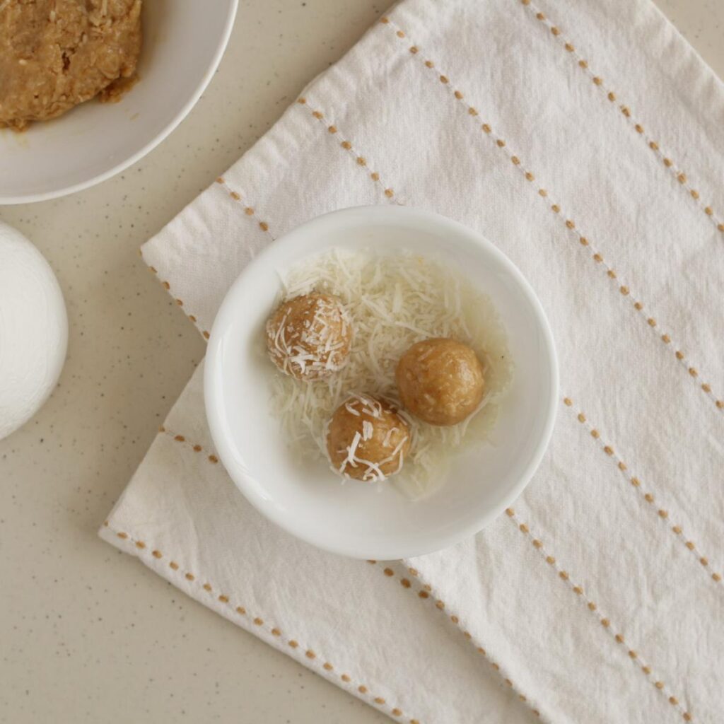 coating snowballs in shredded coconut
