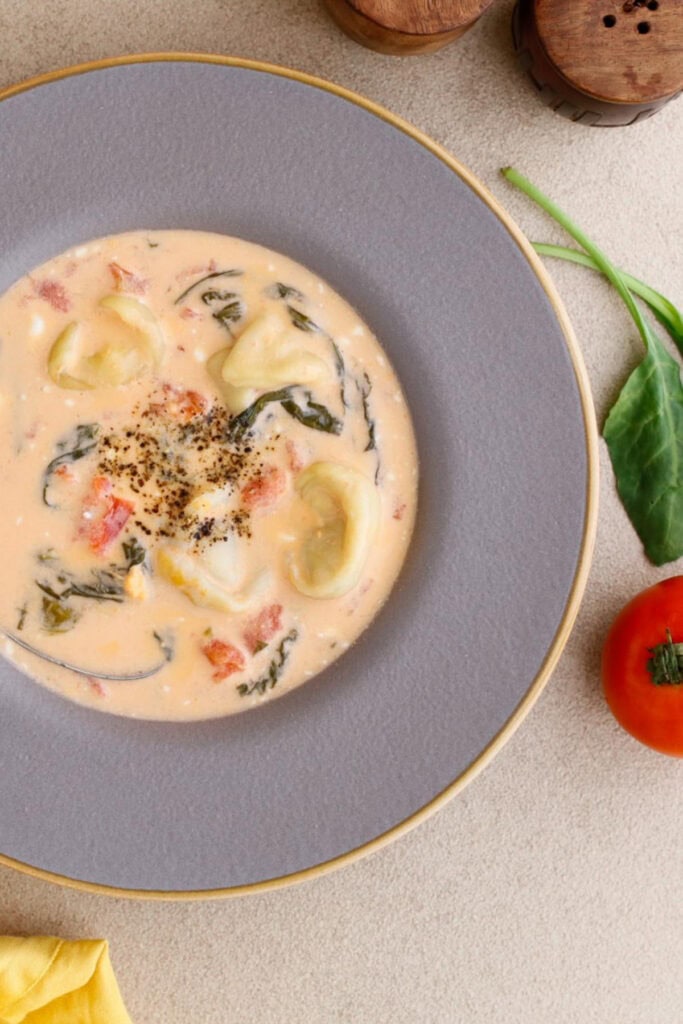 bowl of soup with tortellini and spinach