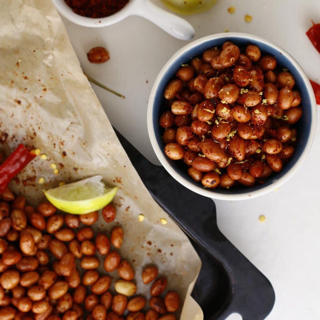bowl of seasoned peanuts with lemon zests