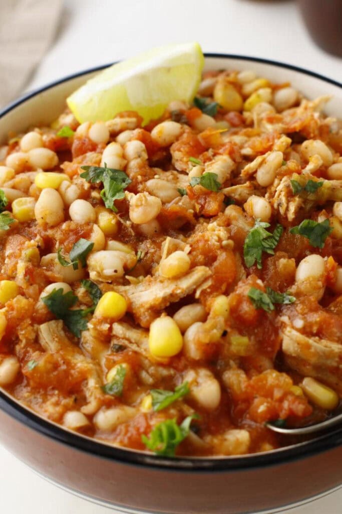 close up of chili beans with corn and lemon