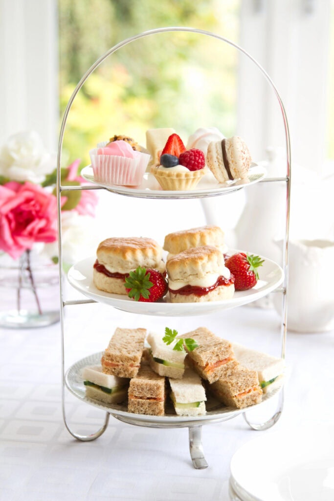 tiered tray with mini sandwiches and treats at a party